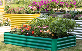 Colorful raised garden beds filled with blooming flowers arranged outdoors on grass.