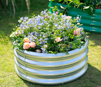 A raised circular garden bed filled with a vibrant mix of colorful flowers.